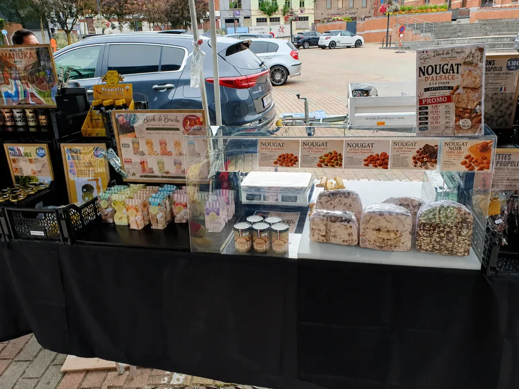 Stand Trésor de la Nature proposant des nougats artisanaux d'Alsace, des guimauves artisanales et des spécialités au miel sur un marché en Belgique