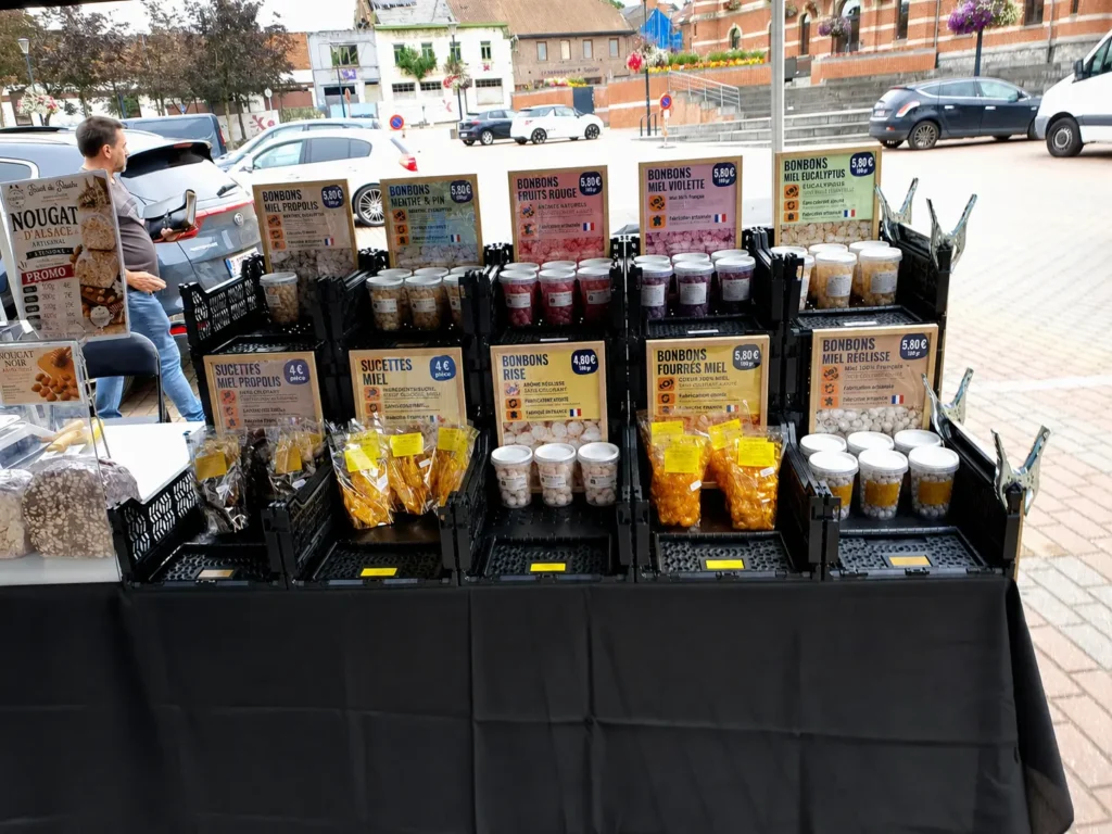 Stand Trésor de la Nature avec bonbons artisanaux au miel de Provence, sucettes au miel et confiseries artisanales sur un marché en Belgique