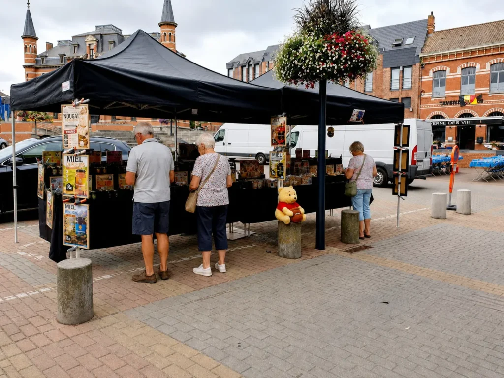Stand Trésor de la Nature sur un marché en Belgique proposant des miels, nougats et confiseries artisanales